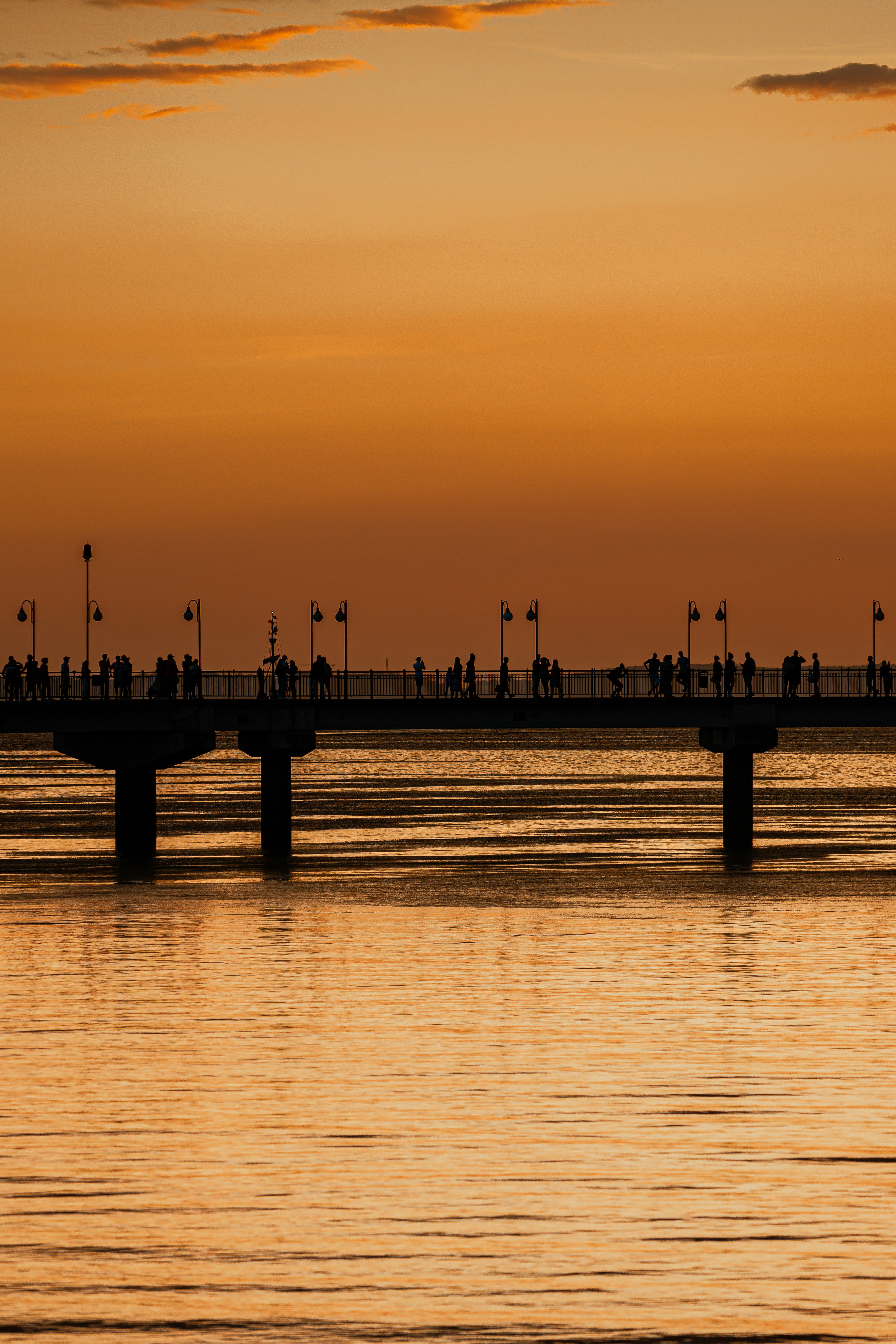 silhouette of people on dock during sunset